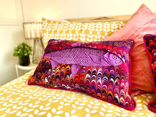 a bed with two pillows with a fish on it at 2 Min Walk to the Best Beach! Stunning Newly Refurbished Stylish 2 Bedroom Apartment! - Great Location - FREE Parking - Fast WiFi - Smart TV - sleeps up to 4! Close to Bournemouth & Poole Town Centre & Sandbanks in Bournemouth