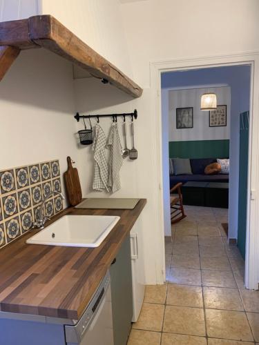 a kitchen with a wooden counter top and a sink at Maison de ville au bord de la rivière ! in Beauvais