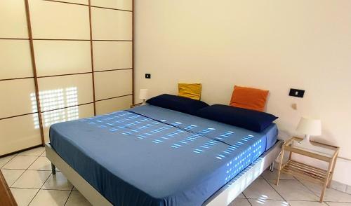 een slaapkamer met een bed met blauwe lakens en oranje kussens bij Chandra GestHouse in Bollate