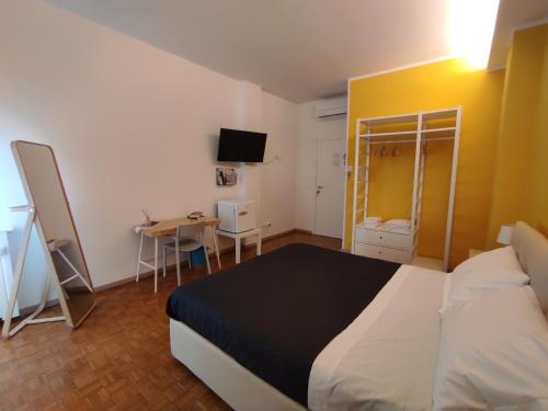 Schlafzimmer mit einem Bett, einem Tisch und einem Schreibtisch in der Unterkunft Il Portico Affittacamere Bologna in Bologna