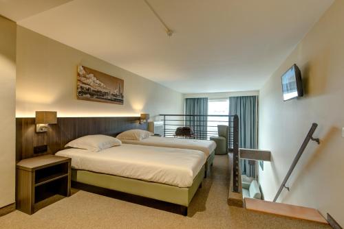 Habitación de hotel con cama y escalera en Arass Hôtel & Business Flats en Amberes