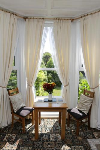 a living room with a table and two chairs and a window at Abbey View Holiday Flats in Torquay
