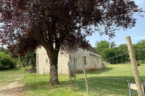 Gîte à Rocamadour في روكامادور: شجرة أمام مبنى به سياج