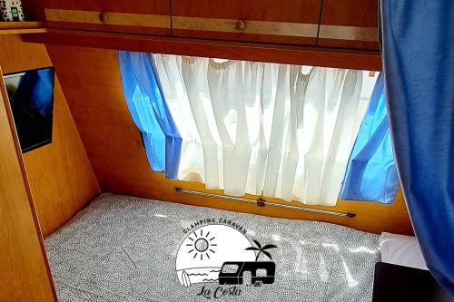 Habitación pequeña con cama y ventana en Glamping Caravan Lanzarote, en Tinajo