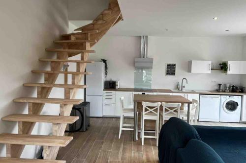 una sala de estar con una escalera de madera en la cocina en Petite grange de charme à Miers, en Miers