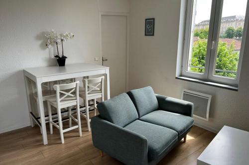 a living room with a blue couch and a table at Gramat appartement centre ville in Gramat