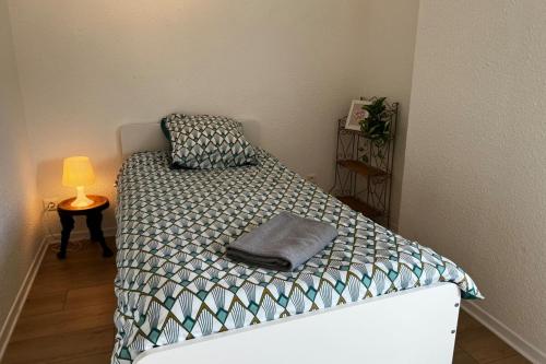 a bedroom with a bed with a pillow and a lamp at Gramat appartement centre ville in Gramat