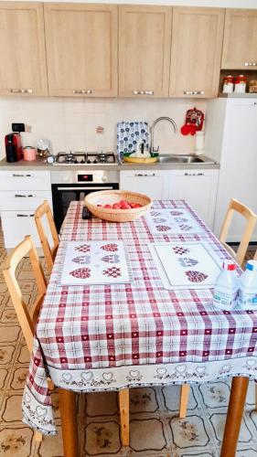 LILLI'S HOME Appartamento confortevole vicino ad Asiago في روانا: مطبخ مع طاولة قماش احمر وبيضاء