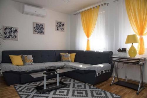 uma sala de estar com um sofá azul e uma mesa em Apartments Oaza em Daruvar