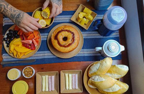 a table with different types of food on it at Tiwá Hostel - antigo DaSanta - CENTRO in Arraial d'Ajuda