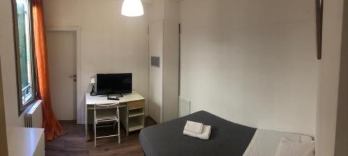 Habitación con cama y escritorio con TV. en SAN FELICE ROOMS en Bolonia