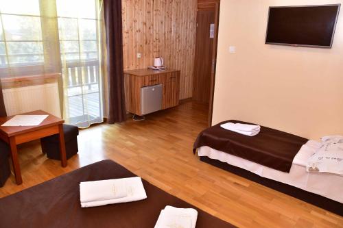 une chambre d'hôtel avec un lit et une télévision dans l'établissement Nad Stawem, à Powidz