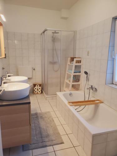 y baño con bañera, lavamanos y ducha. en Familienfreundliche Ferienwohnung Soltau en Soltau