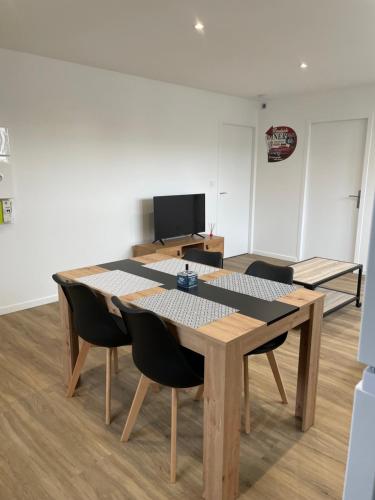 Cette chambre dispose d'une télévision et d'une table avec des chaises. dans l'établissement Résidence Pelloutier Appartement E, à Vénissieux