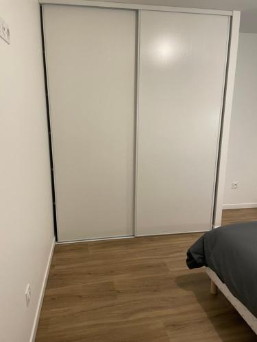 - une chambre avec quatre portes coulissantes dans l'établissement Résidence Pelloutier Appartement E, à Vénissieux