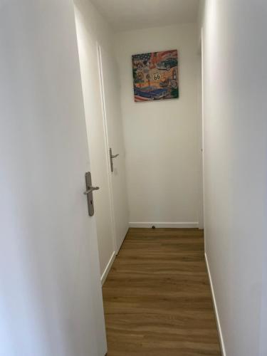 an empty hallway with a cross and a picture on the wall at Résidence Pelloutier Appartement E in Vénissieux