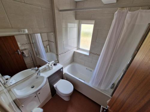 a bathroom with a sink and a toilet and a shower at Grange Lodge Hotel in Saint Peter Port