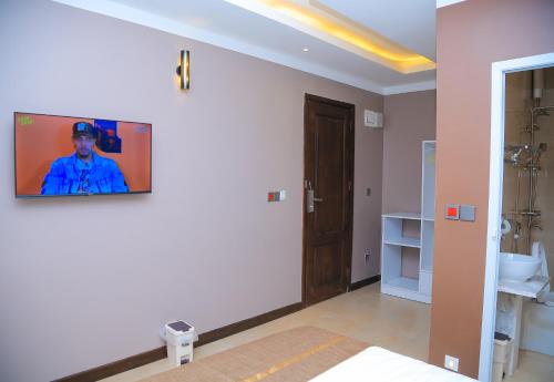 a bathroom with a sink and a tv on the wall at Hotel Amaranth in Dar es Salaam