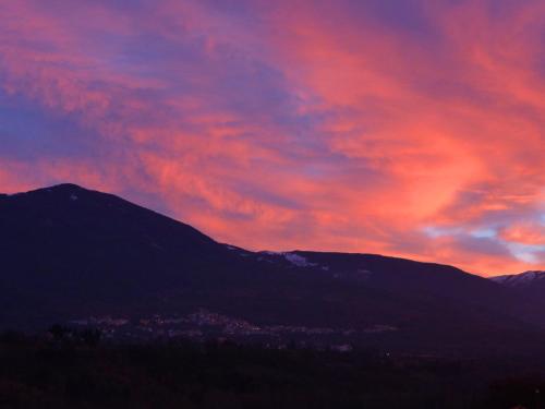 una puesta de sol sobre una cordillera con un cielo rojo en Monteviste, en Bugnara