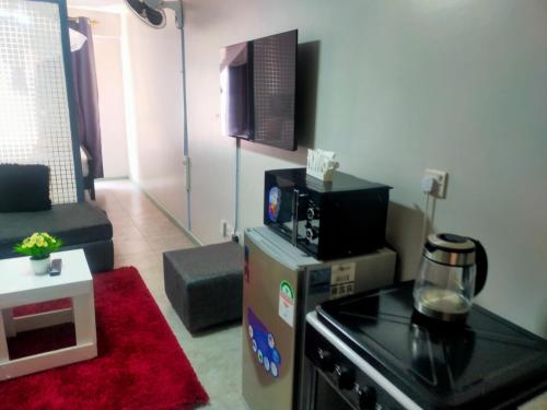 a small living room with a stove and a microwave at Pazoori Furnished Studios and 1 bedrooms in Nairobi