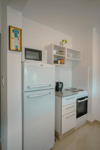 a white kitchen with a refrigerator and a stove at Departamento con vista a las montañas + garage in Salta