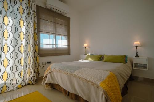 - une chambre avec un grand lit et une fenêtre dans l'établissement Departamento con vista a las montañas + garage, à Salta