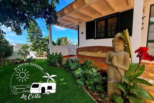 a garden with a statue in front of a house at Glamping Caravan Lanzarote in Tinajo