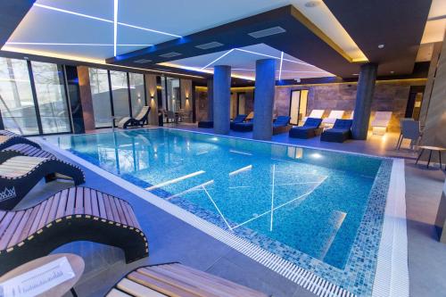 - une grande piscine dans un bâtiment avec des chaises dans l'établissement HOTEL ROYAL MOUNTAIN, à Divčibare
