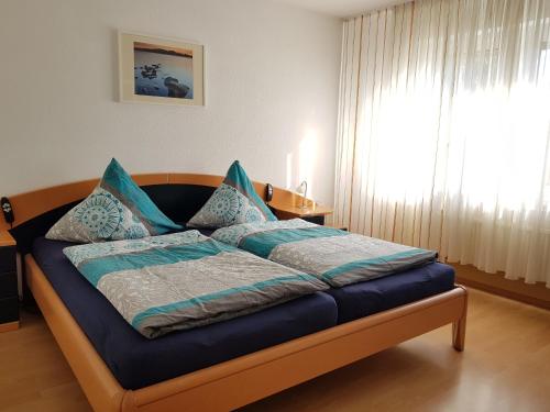 1 dormitorio con cama con sábanas azules y ventana en Ferienwohnung Jansen, en Kirchhundem