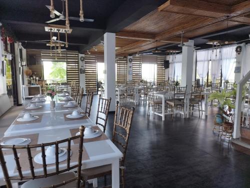IgcauayanにあるRedDoorz @ Marceily Point Resort Guimarasのダイニングルーム(白いテーブル、椅子付)