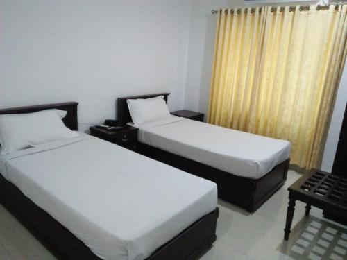 two beds in a hotel room withskirts at MP RESIDANCY in Perintalmanna