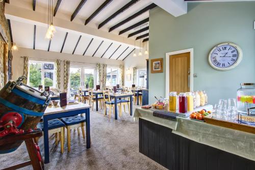 a dining room with a counter and a clock on the wall at Butterchurn Guest House in Otterburn