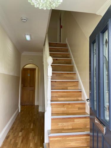 a staircase in a home with wooden floors and a chandelier at The White Lodge Hotel in Hereford