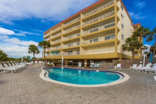 a hotel with a swimming pool in front of a building at 208 Madeira Norte Condo in St Pete Beach