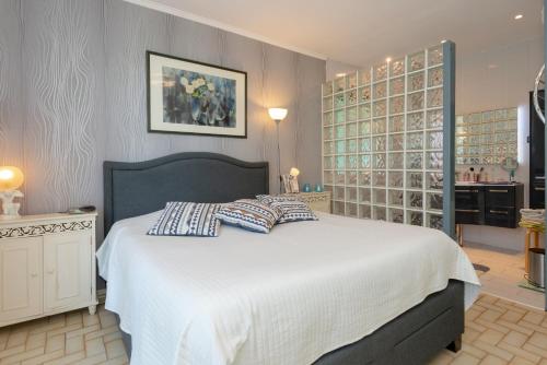 ein Schlafzimmer mit einem großen weißen Bett mit Kissen darauf in der Unterkunft Maison dans un parc de verdure in Verthemex
