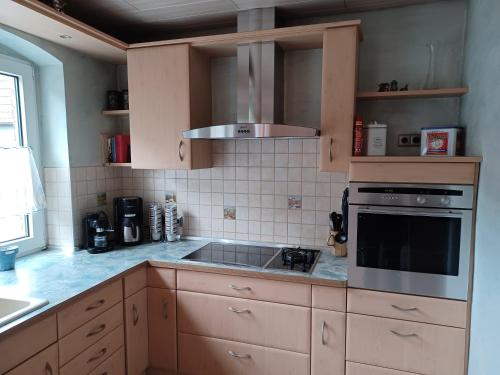 een keuken met een wastafel en een fornuis top oven bij JANs in Herdorf
