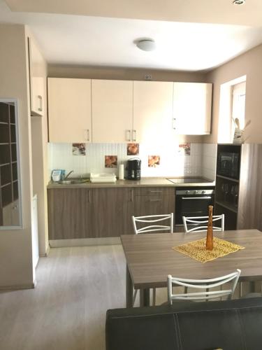 a kitchen with a table and chairs in a room at Diszkrét szállás in Szekszárd