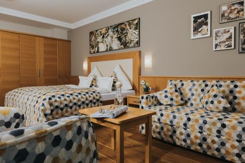 a hotel room with two beds and a couch at Ortner's Resort in Bad Füssing