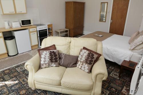 een woonkamer met een bank en een bed bij Abbey View Holiday Flats in Torquay