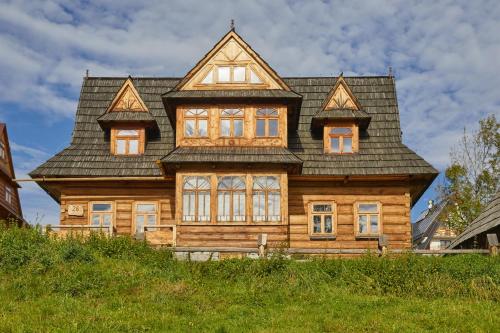 duży drewniany dom na szczycie wzgórza w obiekcie Hruby Gazda - zabytkowa willa góralska na wyłączność w Bukowinie Tatrzańskiej