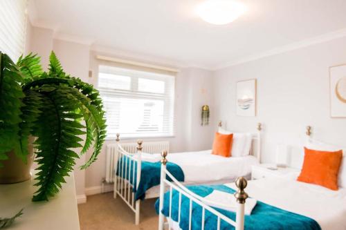 a bedroom with two beds and a large window at Mumbles Apartment near to shops and beach in The Mumbles