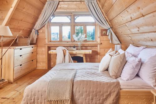 sypialnia w drewnianym domku z łóżkiem i biurkiem w obiekcie Hruby Gazda - zabytkowa willa góralska na wyłączność w Bukowinie Tatrzańskiej