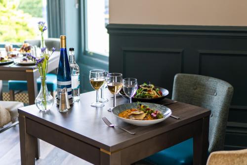 a table with a plate of food and glasses of wine at The Lansdowne, Eastbourne in Eastbourne