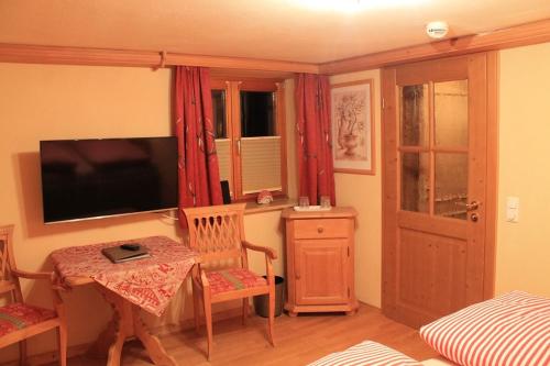 a room with a table and a television and a bedroom at Winklmoos Sonnenalm in Reit im Winkl