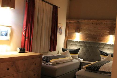 a bedroom with two beds and a dresser at Winklmoos Sonnenalm in Reit im Winkl