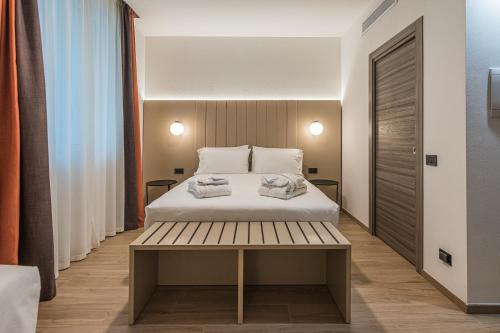 a bedroom with a bed and a wooden bench at BB Hotels Smarthotel Duomo in Milan