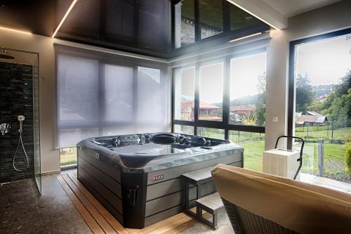 a large bathroom with a large tub in front of a window at MOUNTAIN HILL LUXURY VILLA in Madzhare