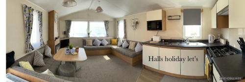 een keuken en een woonkamer met een bank en een tafel bij Coastfields 3 bed 8 berth holiday home in Ingoldmells