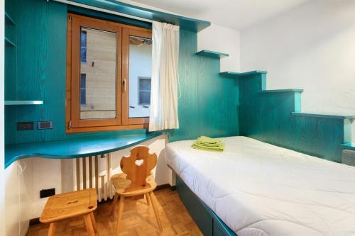 um pequeno quarto com 2 camas e uma janela em Appartamento Laura em Bormio