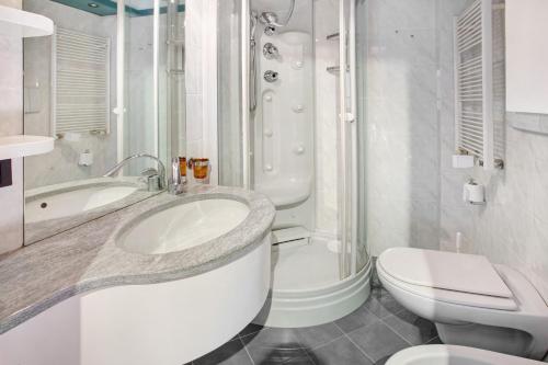 uma casa de banho branca com um lavatório e um WC em Appartamento Laura em Bormio